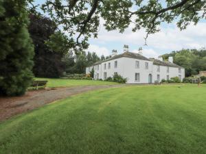 a large white house with a large green yard at Westward Park in Wigton