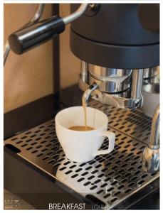 a cup of coffee is being brewed in a coffee machine at San Paolo Design Suites in Piacenza +39 photos
