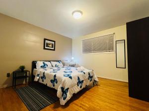 a bedroom with a bed with a white and blue comforter at Cozy Stay, Self Check-In with Parking available upon request in Toronto