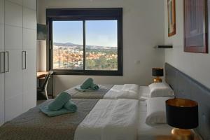 een slaapkamer met twee bedden en een groot raam bij villasroyale Silvermoon in San Bartolomé +46 foto's