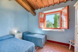 a bedroom with two beds and a window at Poggio D'Arno in Asciano +48 photos
