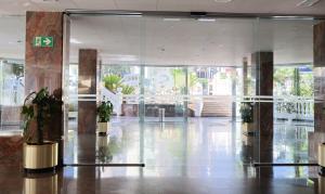 a lobby with glass doors and potted plants in a building at Santa Monica Playa in Salou