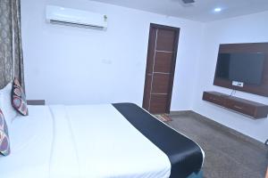 une chambre avec un lit et une télévision à écran plat dans l'établissement Hotel Golden By Admire Stay, à Jāmb