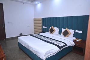 une chambre avec un grand lit avec des draps et des oreillers blancs dans l'établissement Hotel Golden By Admire Stay, à Jāmb 16 autres photos