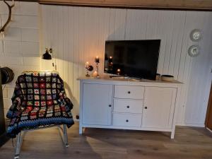 a white dresser with a television on top of it at Skønt feriehus til 6 personer, Sjælland in Gørlev