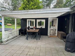 a pavilion with a table and chairs on a patio at Skønt feriehus til 6 personer, Sjælland in Gørlev