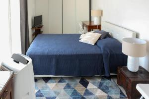 a bedroom with a bed with a blue bedspread at Villa Casa Bianca Beachfront Villeroy in Sète