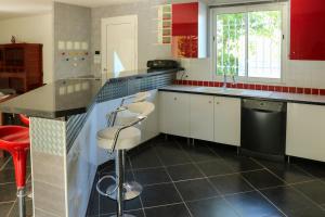 a kitchen with white cabinets and a black counter top at Villa Casa Bianca Beachfront Villeroy in Sète