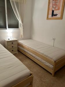 una camera da letto con due letti, un comò e una finestra di Casa Lily on Vistabella Golf a Vistabella