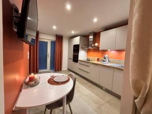 a kitchen with a white table and a table and chairs at Cocon Urbain à Saint-Leu-d'Esserent in Saint-Leu-dʼEsserent