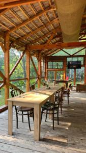 a large wooden table and chairs in a pavilion at Mesteceni Glamping in Nistoreşti
