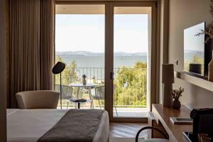 a hotel room with a bed and a view of the ocean at Upon Vila - Alcochete Hotel in Alcochete