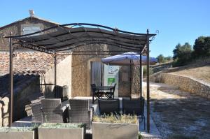 een patio met een parasol en een tafel en stoelen bij Gite "panda" la vincence in La Verdière