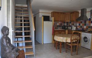 een keuken met een tafel en een keuken met een koelkast bij Gite "panda" la vincence in La Verdière