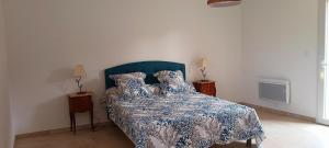 een slaapkamer met een bed met een blauw en wit dekbed bij Gite "panda" la vincence in La Verdière