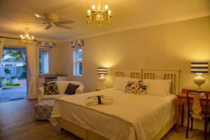 a bedroom with a bed and a chandelier at Bright on 5th Guest house in Port Elizabeth