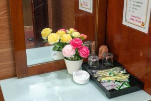 a table with a vase of flowers on it at Pho Nang Motel in Hanoi