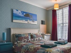 a bedroom with a bed and a window with avertisement at Vincent House in Scarborough