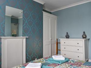 a bedroom with a bed and a dresser and a mirror at Vincent House in Scarborough