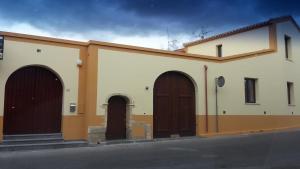 a building with three brown doors on the side of it at Residenza Tre Archi in Sìnnai