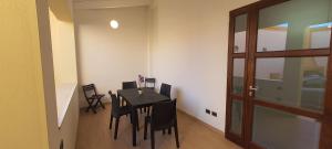 een eetkamer met een tafel en stoelen en een deur bij Residenza Tre Archi in Sìnnai +35 foto's