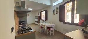 een keuken met een spoelbak en een tafel met stoelen bij Residenza Tre Archi in Sìnnai
