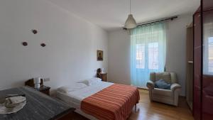a bedroom with a bed and a chair and a window at casAmare in Pescara