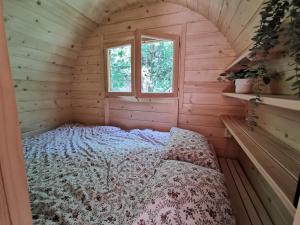 a bed in a wooden room with a window at Hope Mountain Escape Poland, Charming Barrel House in Szczawa