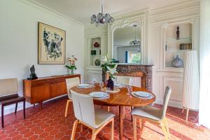 a dining room with a table and a piano at Le Logis - Charmante Maison Proche Plage in Rosendaël +7 photos