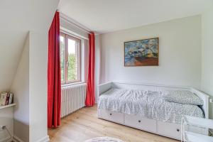 a bedroom with a bed and a window at Le Logis - Charmante Maison Proche Plage in Rosendaël