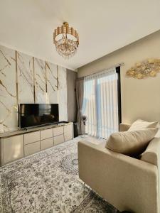 a living room with a couch and a television at Arrayyan Executive Village Kota Batu in Batu