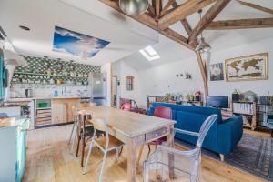 a kitchen and living room with a wooden table and chairs at La Maison des Docks - 30min de Tours in Villaines-les-Rochers