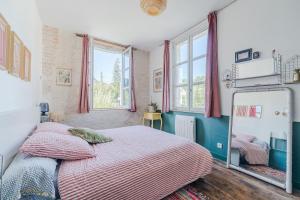 a bedroom with a bed and a mirror at La Maison des Docks - 30min de Tours in Villaines-les-Rochers