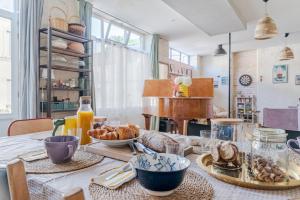 a dining room table with breakfast foods and orange juice at La Maison des Docks - 30min de Tours in Villaines-les-Rochers +6 photos