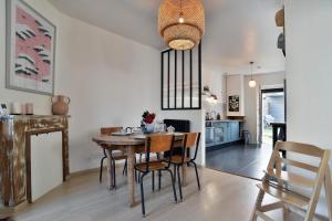 a dining room and kitchen with a table and chairs at Kerchoupi - Proche centre-ville Saint Malo in Saint Malo +7 photos