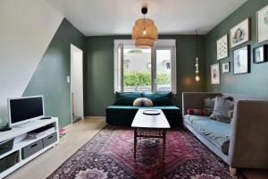a living room with a couch and a tv at Kerchoupi - Proche centre-ville Saint Malo in Saint Malo