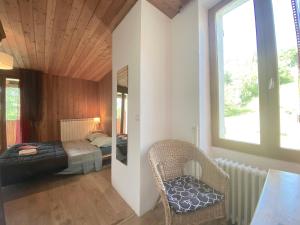 a bedroom with a bed and a chair and a window at CASA-Lodge Lili pour 2 personnes in Molines-en-Queyras