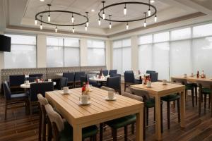 un ristorante con tavoli e sedie in legno e finestre di Hilton Garden Inn Richmond South/Southpark a Colonial Heights