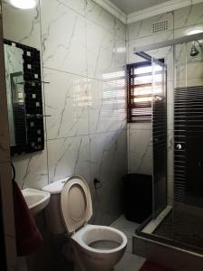 a bathroom with a toilet and a shower and a sink at Carissa Street Self-catering Units in Burgersfort +21 photos
