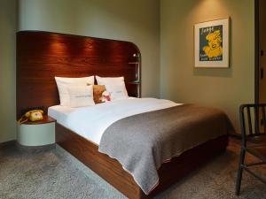 a bedroom with a large bed with a teddy bear on it at 25hours Hotel Hamburg HafenCity in Hamburg
