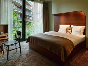 a bedroom with a large bed and a large window at 25hours Hotel Hamburg HafenCity in Hamburg
