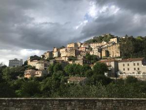 a town on top of a hill with houses at To a Book House in Corsica - chambres d'hôtes in Oletta