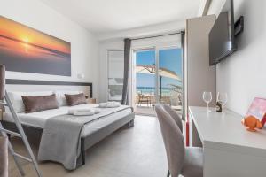 a bedroom with a bed and a balcony with the ocean at Nella Suites Rooms in Torre Lapillo