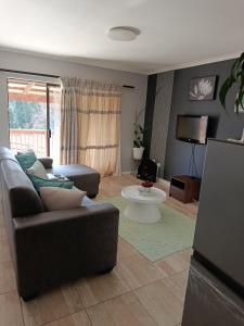 a living room with a couch and a tv at Cleo's Corner in East London