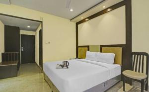 a bedroom with a large white bed and a chair at Hotel Namaste Inn in Hyderabad