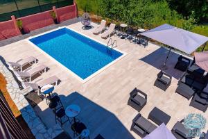 an overhead view of a swimming pool with chairs and umbrellas at Apartman Sedmica in Danilovgrad