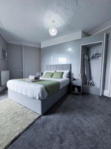 a bedroom with a large bed and a chandelier at Thornleigh Guest House - Free ON STREET Parking in Windermere