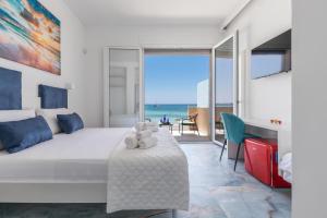 a bedroom with a bed and a view of the ocean at Nella Suites Rooms in Torre Lapillo