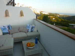a balcony with a couch and a bowl of fruit at Apartment Joaquin in Frigiliana