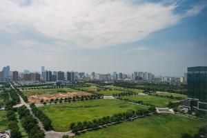 Hi-Home Suites - Ngoai Giao Doan at West Lake Starlake في هانوي: اطلالة جوية على حديقة وخلفها مدينة